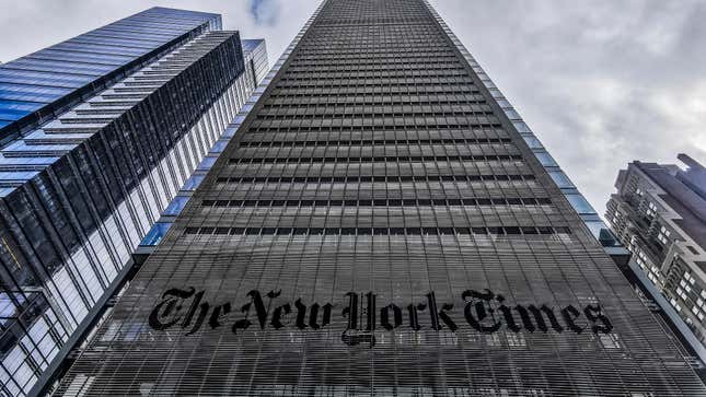 A large grey skyscraper, with "The New York Times" across the front, rises into to Manhattan skyline, flanked by other buildings